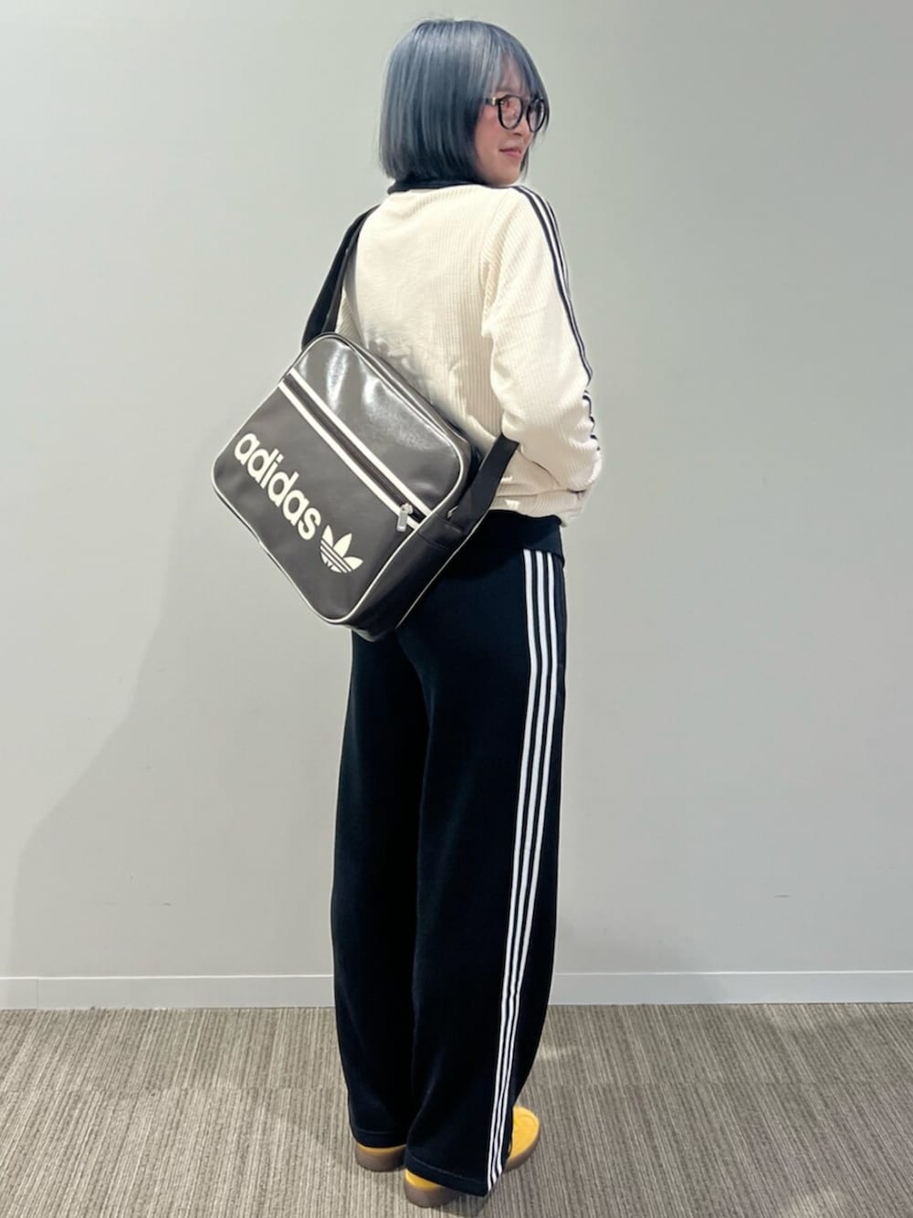 ブラック系のスウェットパンツ、ブラウン系のバッグ、ホワイト系のジャージを着用したレディースの秋コーディネートの2枚目の写真