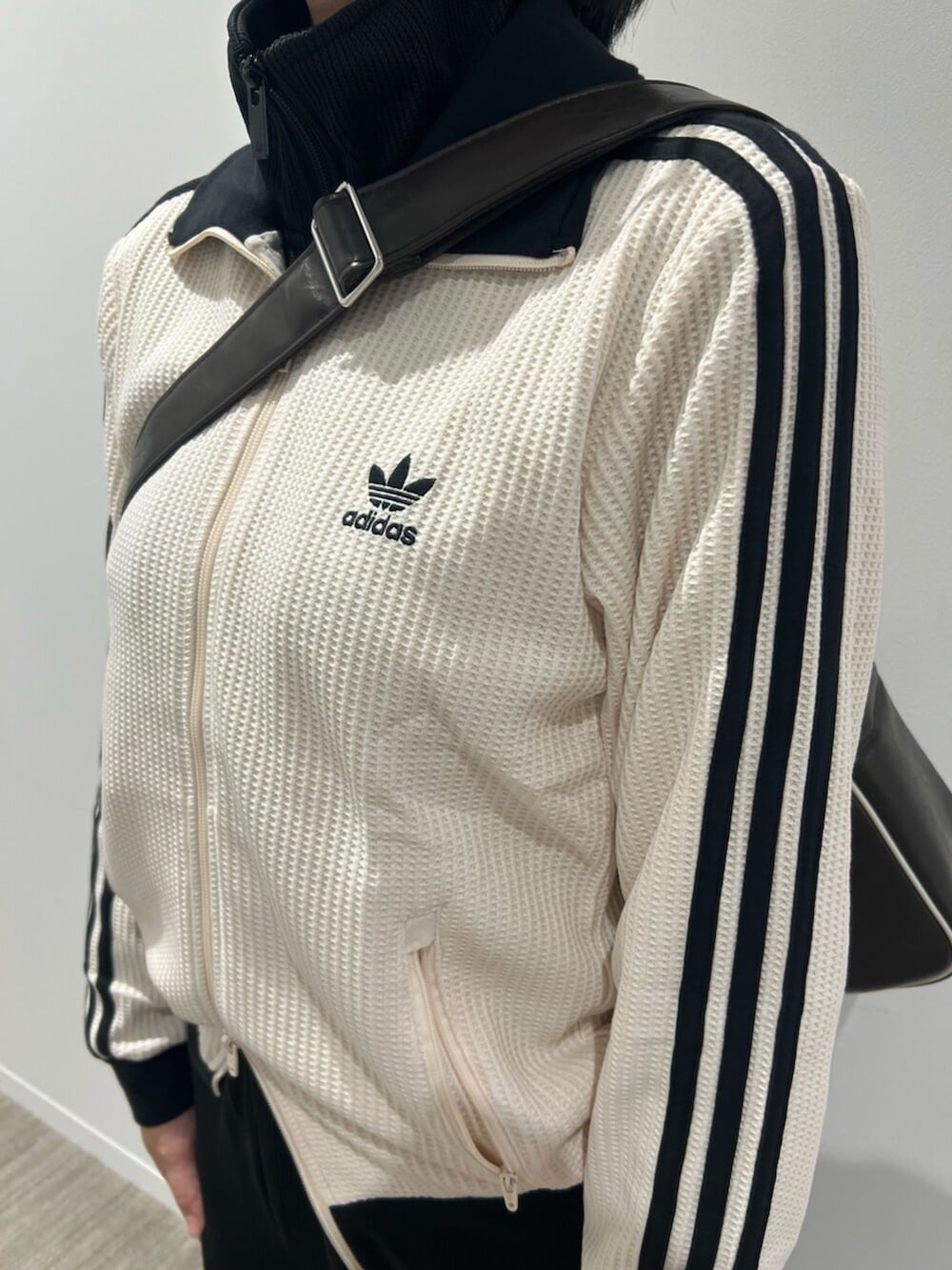 ブラック系のスウェットパンツ、ブラウン系のバッグ、ホワイト系のジャージを着用したレディースの秋コーディネートの3枚目の写真