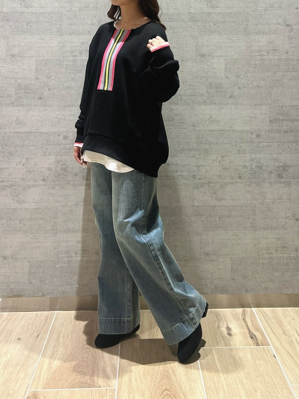 ブラック系のスウェット、ホワイト系のTシャツ/カットソー、ブルー系のデニムパンツを着用したレディースの冬コーディネートの3枚目の写真