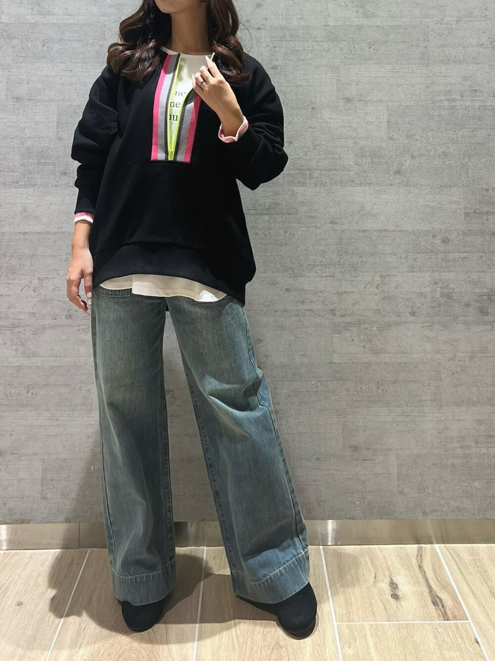 ブラック系のスウェット、ホワイト系のTシャツ/カットソー、ブルー系のデニムパンツを着用したレディースの冬コーディネートの2枚目の写真