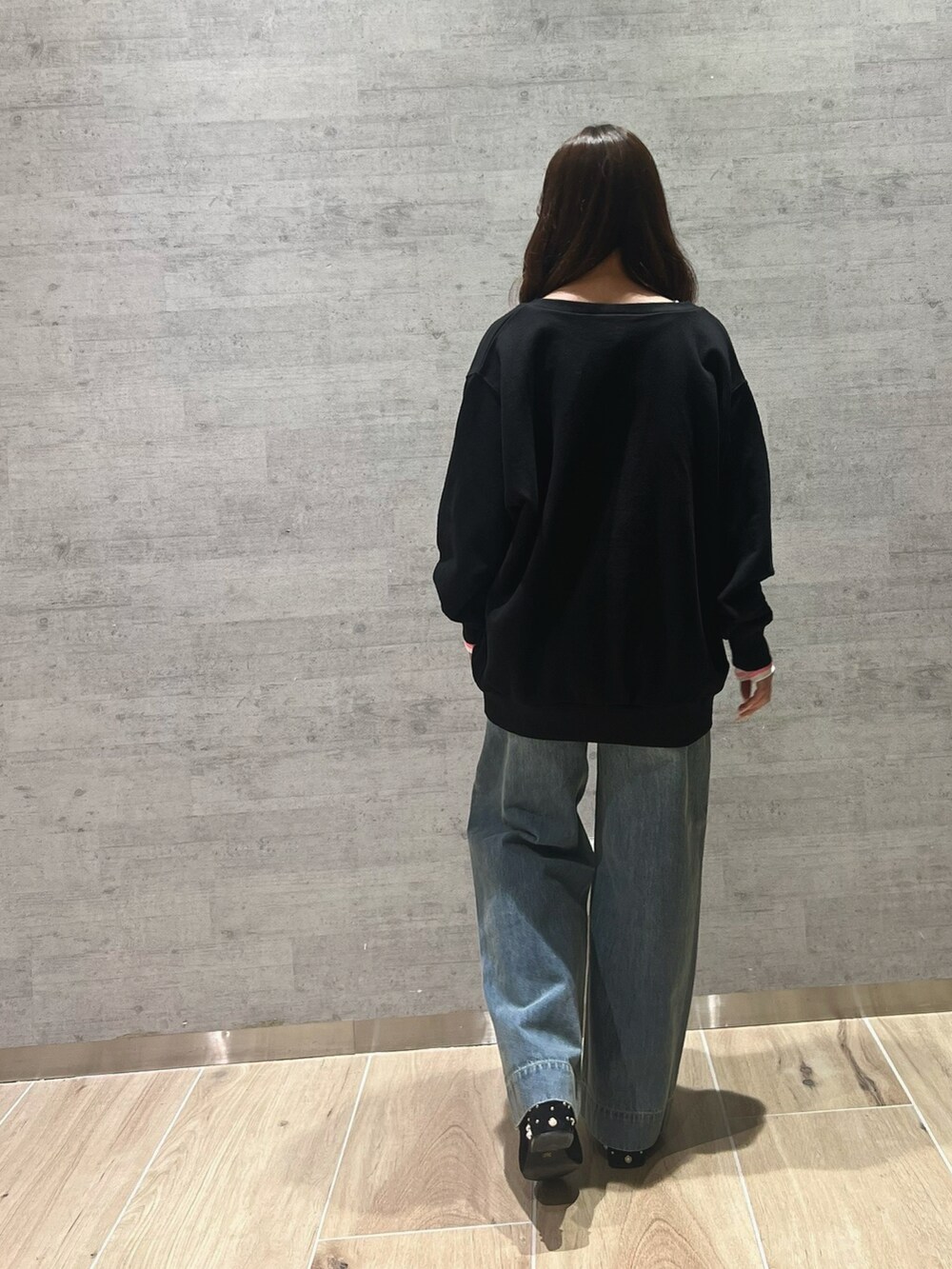 ブラック系のスウェット、ホワイト系のTシャツ/カットソー、ブルー系のデニムパンツを着用したレディースの冬コーディネートの4枚目の写真