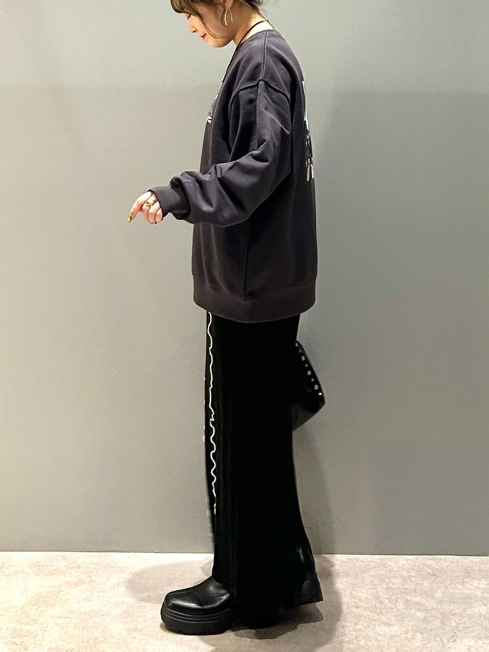 ブラック系のブーツ、ブラック系のハンドバッグ、グレー系のスウェットを着用したレディースの冬コーディネートの6枚目の写真