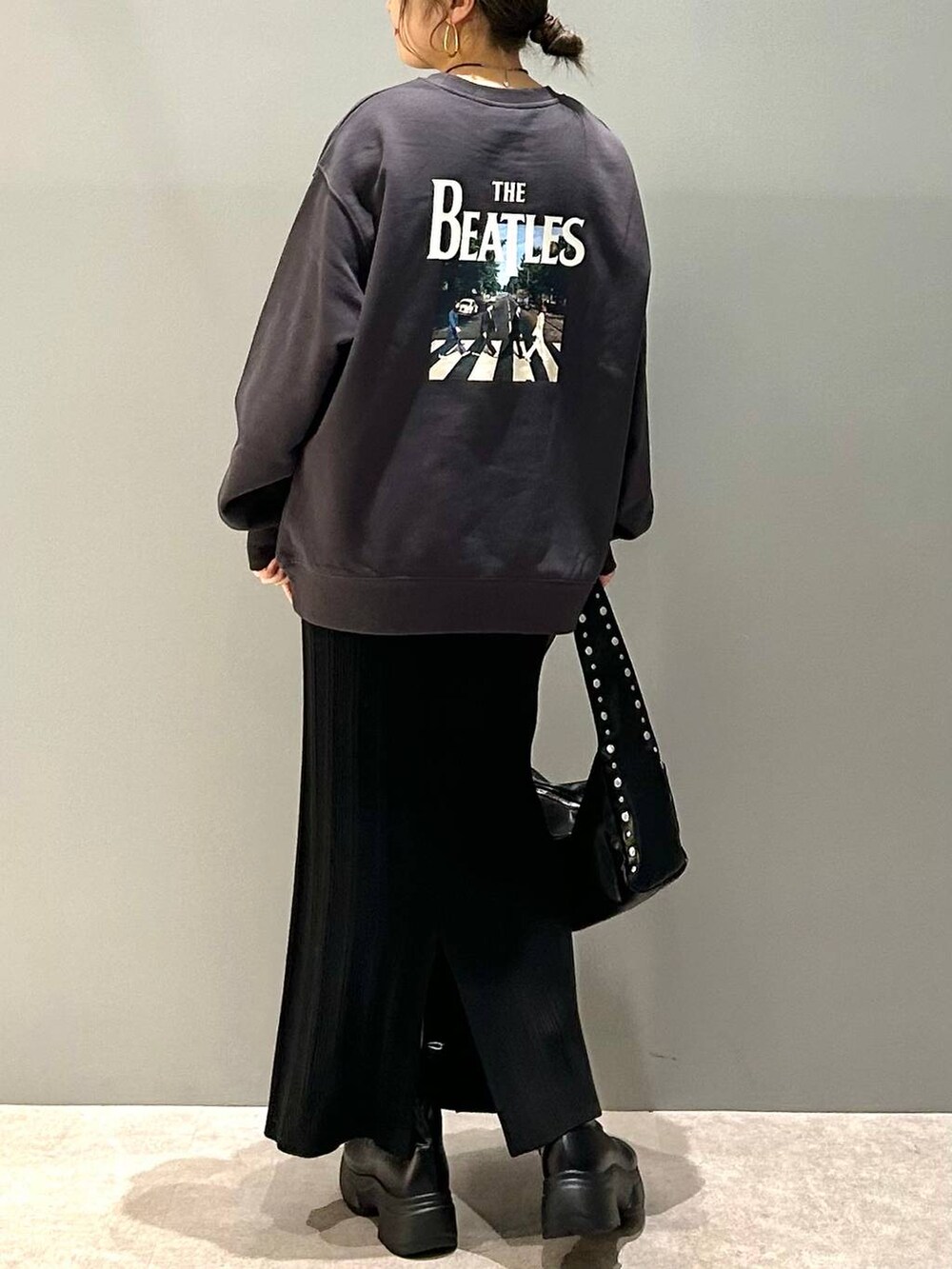 ブラック系のブーツ、ブラック系のハンドバッグ、グレー系のスウェットを着用したレディースの冬コーディネートの3枚目の写真