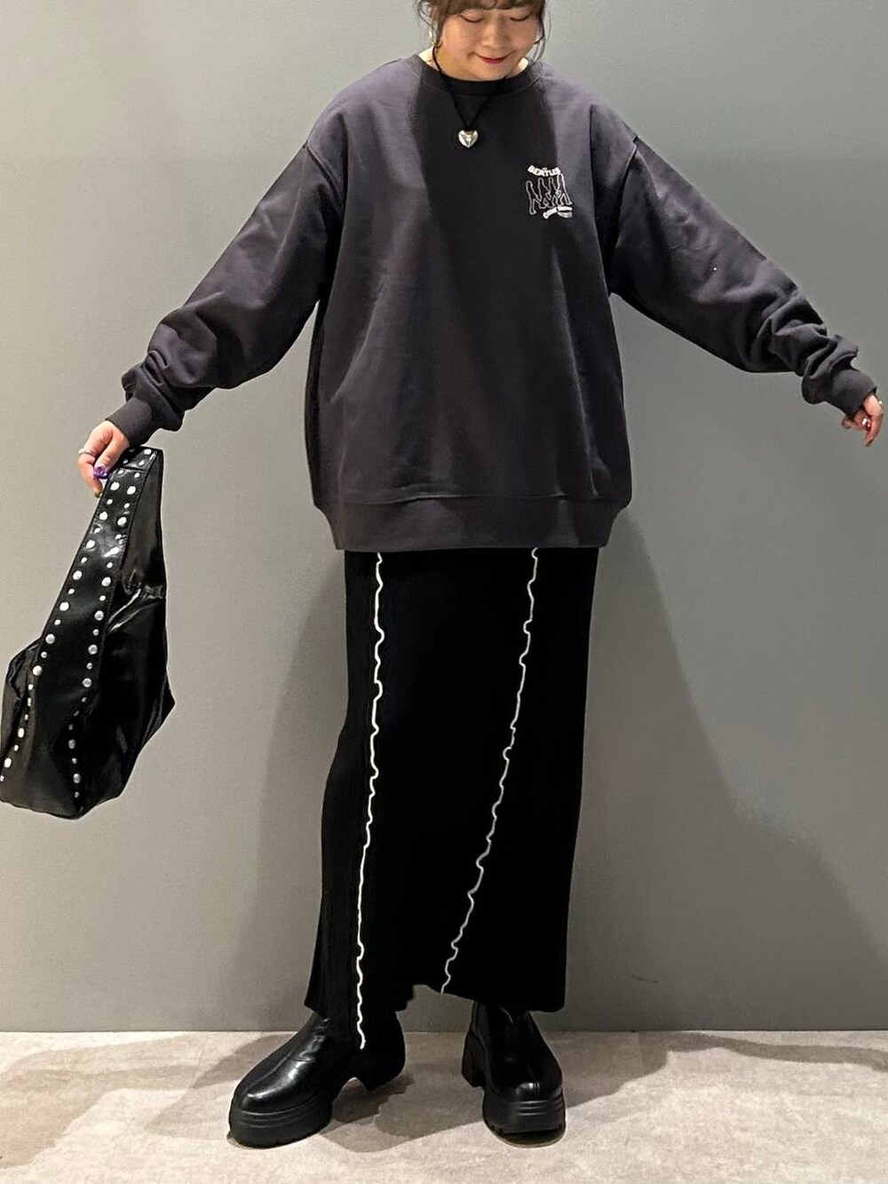 ブラック系のブーツ、ブラック系のハンドバッグ、グレー系のスウェットを着用したレディースの冬コーディネートの7枚目の写真