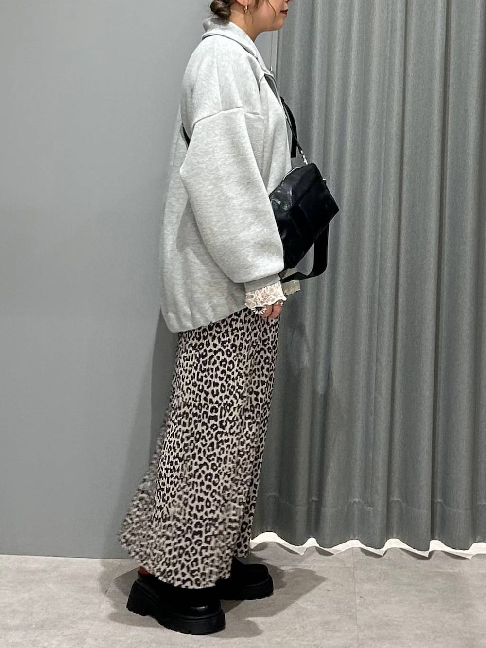 ブラック系のその他シューズ、ホワイト系のシャツ/ブラウス、グレー系のカーディガン/ボレロを着用したレディースの春コーディネートの2枚目の写真