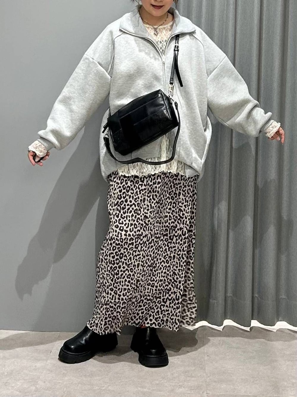 ブラック系のその他シューズ、ホワイト系のシャツ/ブラウス、グレー系のカーディガン/ボレロを着用したレディースの春コーディネートの7枚目の写真