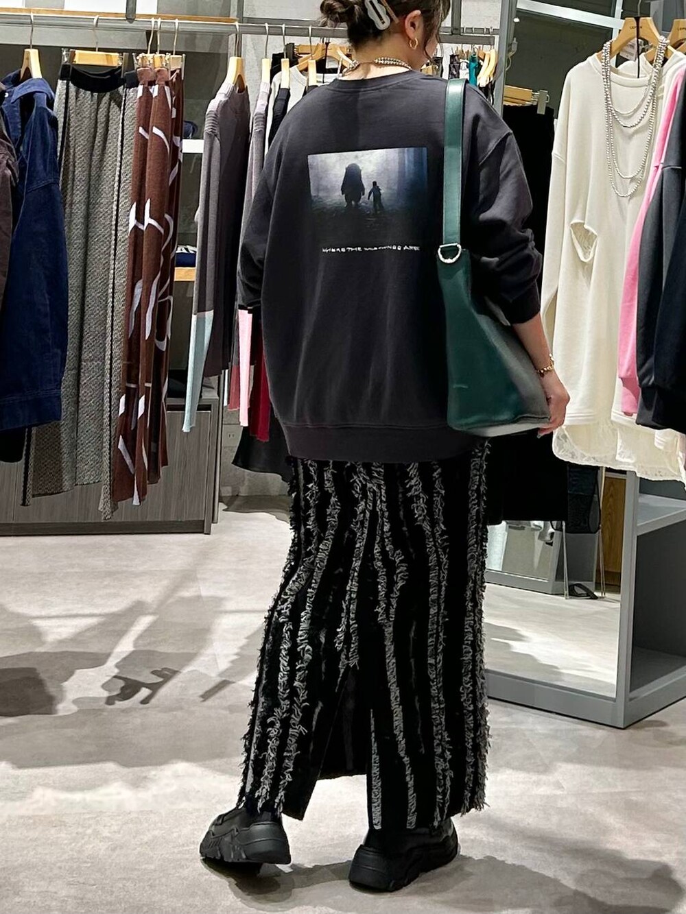 ブラック系のスニーカー、グリーン系のショルダーバッグ、ブラック系のスカートを着用したレディースの秋コーディネートの7枚目の写真