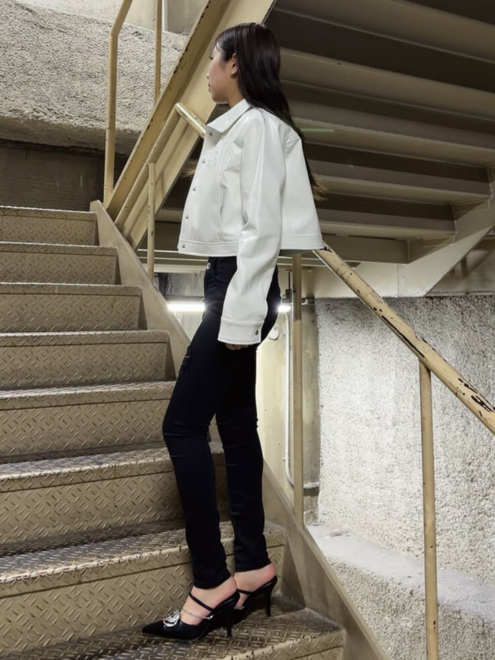 ブラック系のパンプス、ブラック系のTシャツ/カットソー、ブラック系のデニムパンツを着用したレディースの春コーディネートの3枚目の写真