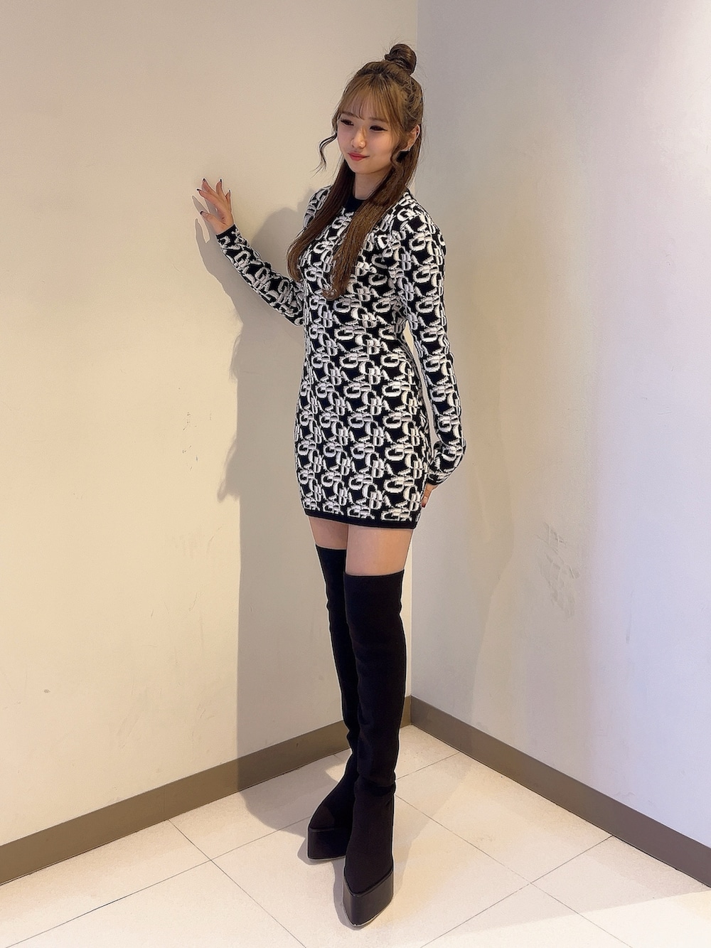 ブラック系のワンピース、ブラック系のブーツを着用したレディースの秋コーディネートの3枚目の写真