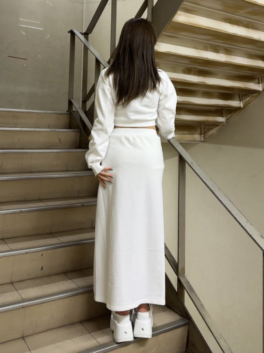 ホワイト系のスカート、ホワイト系のスウェット、ホワイト系のサンダルを着用したレディースの冬コーディネートの4枚目の写真