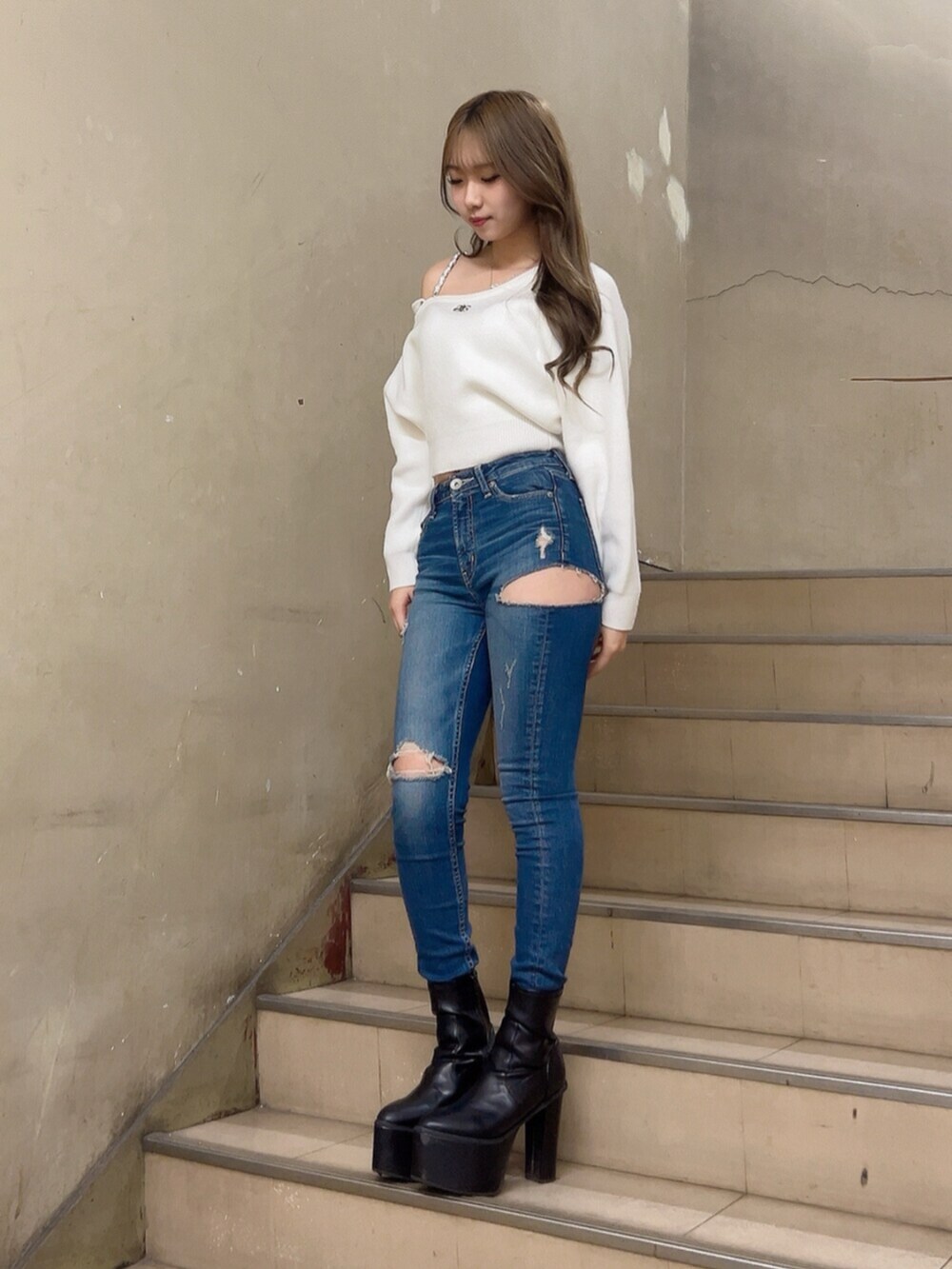 ブルー系のデニムパンツ、ホワイト系のニット/セーター、ブラック系のブーツを着用したレディースの秋コーディネートの6枚目の写真