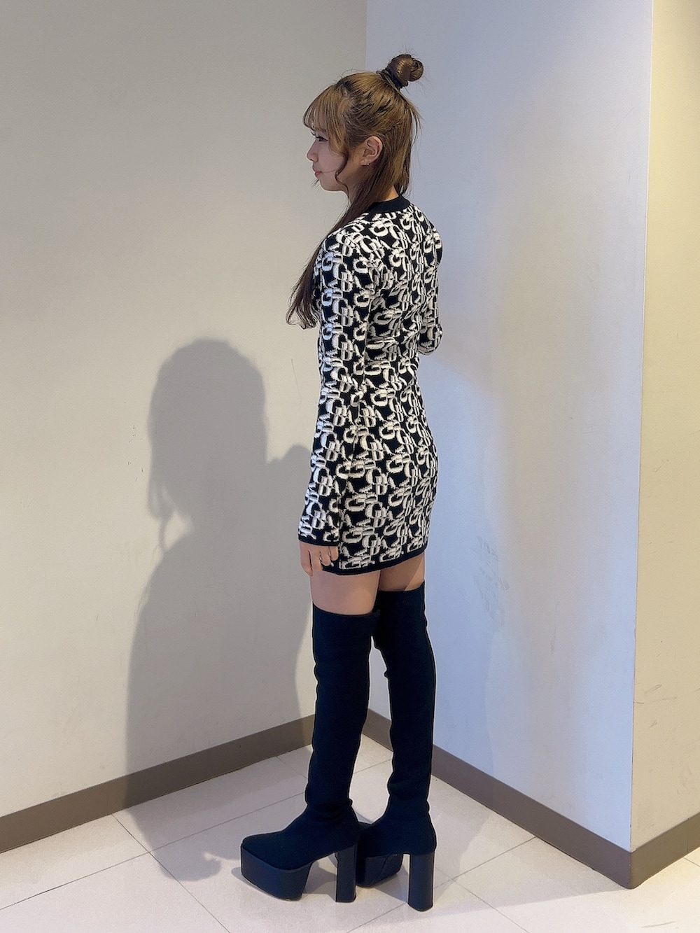 ブラック系のワンピース、ブラック系のブーツを着用したレディースの秋コーディネートの2枚目の写真