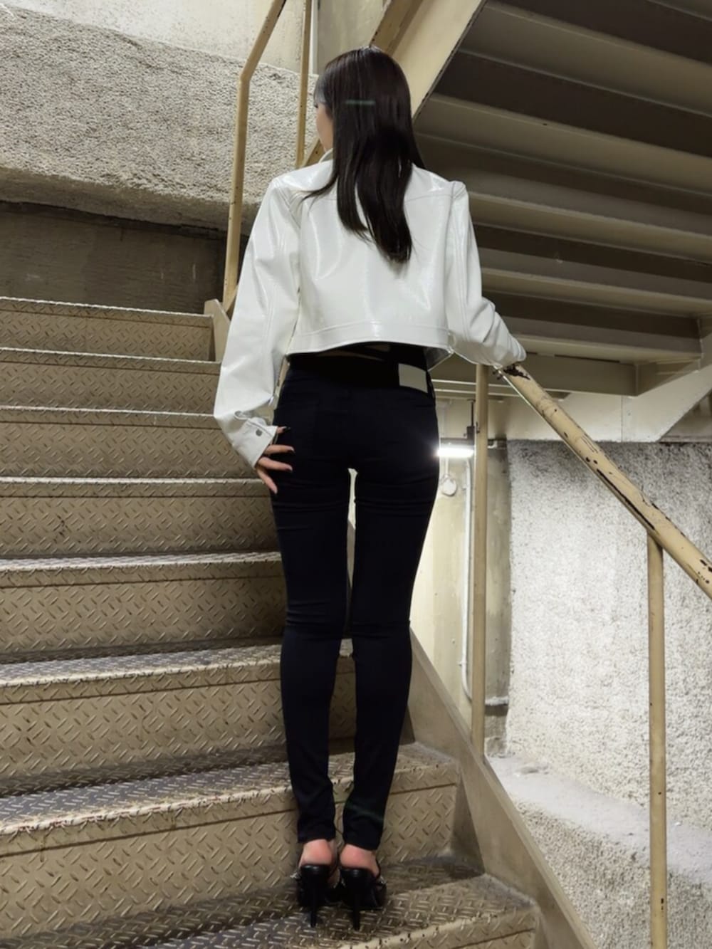 ブラック系のパンプス、ブラック系のTシャツ/カットソー、ブラック系のデニムパンツを着用したレディースの春コーディネートの4枚目の写真