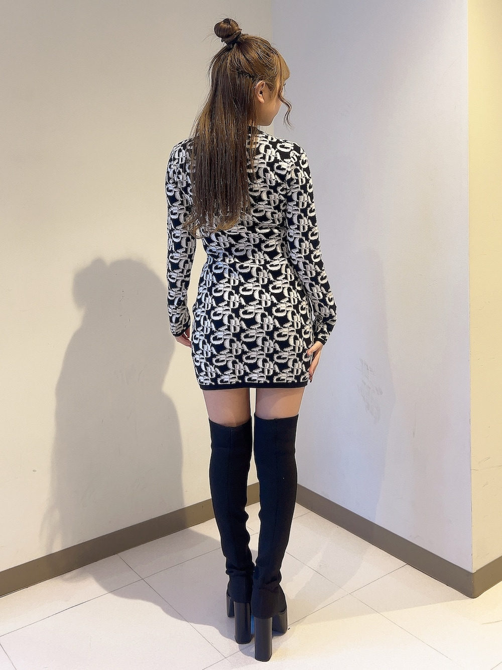 ブラック系のワンピース、ブラック系のブーツを着用したレディースの秋コーディネートの4枚目の写真