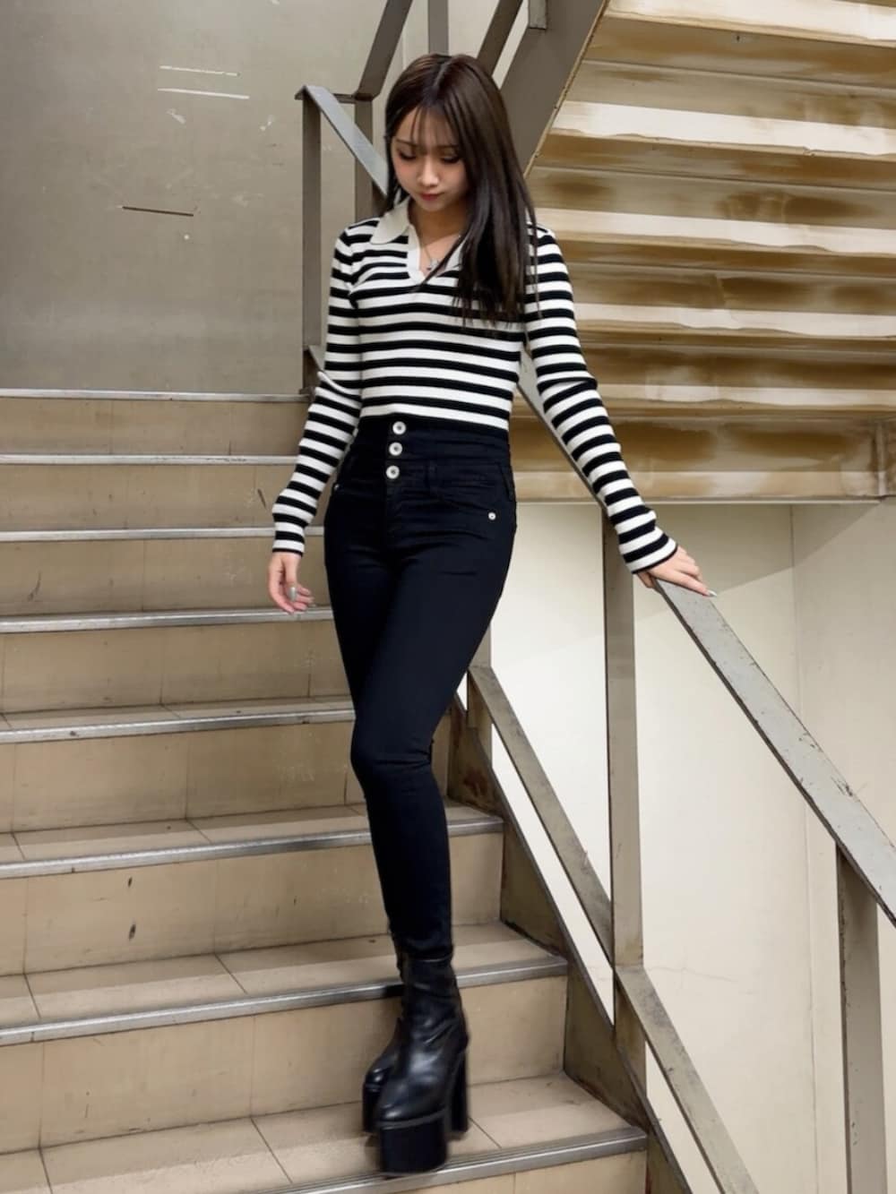 ブラック系のブーツ、ブラック系のデニムパンツ、その他のニット/セーターを着用したレディースの冬コーディネートの2枚目の写真