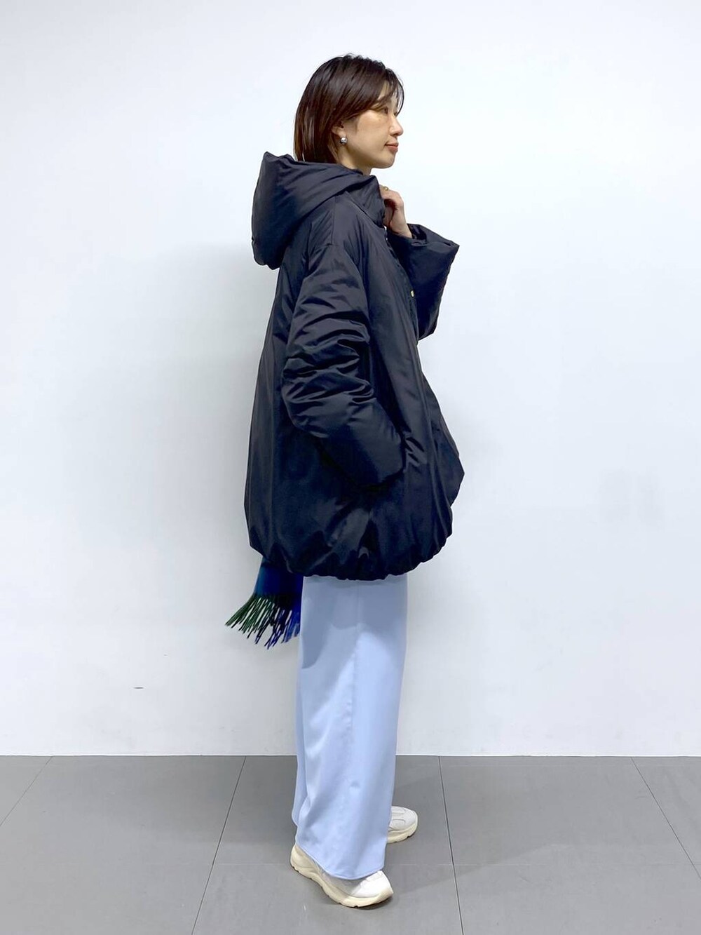 ホワイト系のショルダーバッグ、ブラック系のダウンジャケット/コート、ブルー系のその他パンツを着用したレディースの秋コーディネートの3枚目の写真