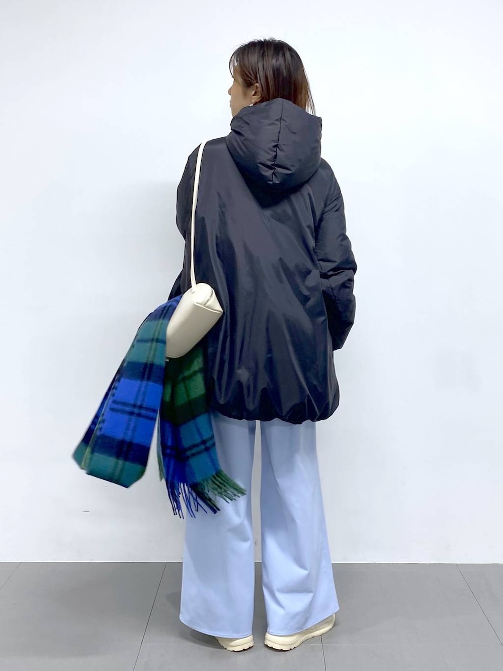 ホワイト系のショルダーバッグ、ブラック系のダウンジャケット/コート、ブルー系のその他パンツを着用したレディースの秋コーディネートの4枚目の写真