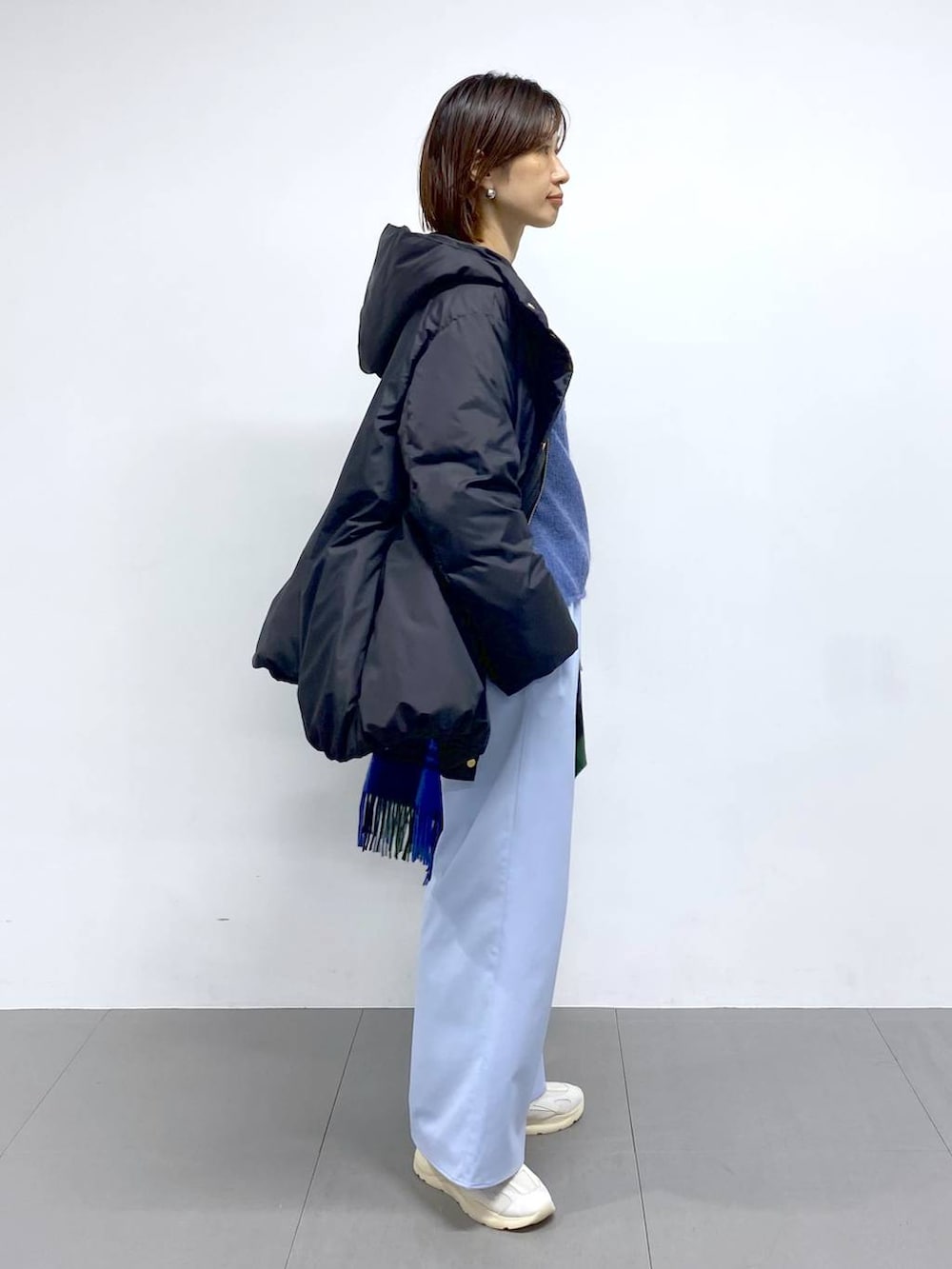 ホワイト系のショルダーバッグ、ブラック系のダウンジャケット/コート、ブルー系のその他パンツを着用したレディースの秋コーディネートの6枚目の写真