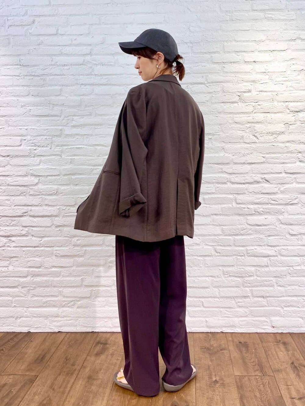 ブラック系のボストンバッグ、ブラウン系のスラックス、ホワイト系のTシャツ/カットソーを着用したレディースの夏コーディネートの3枚目の写真