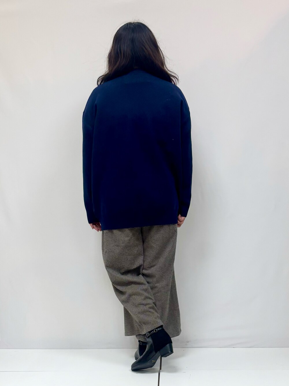 ブルー系のニット/セーター、グレー系のその他パンツ、ブラック系のブーツを着用したレディースの冬コーディネートの3枚目の写真