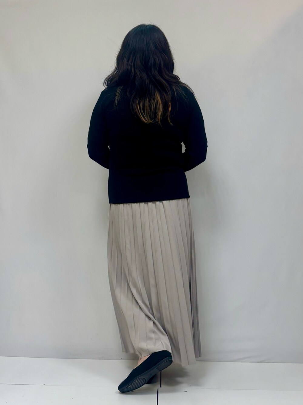 ブラック系のスカート、ブラック系のパンプスを着用したレディースの冬コーディネートの3枚目の写真