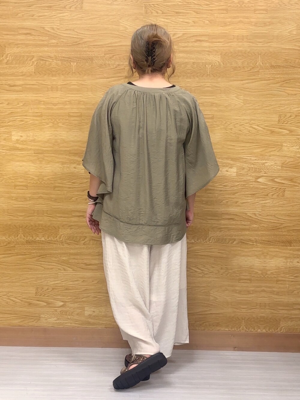 ベージュ系のその他パンツ、その他のサンダル、グリーン系のシャツ/ブラウスを着用したレディースの春コーディネートの3枚目の写真