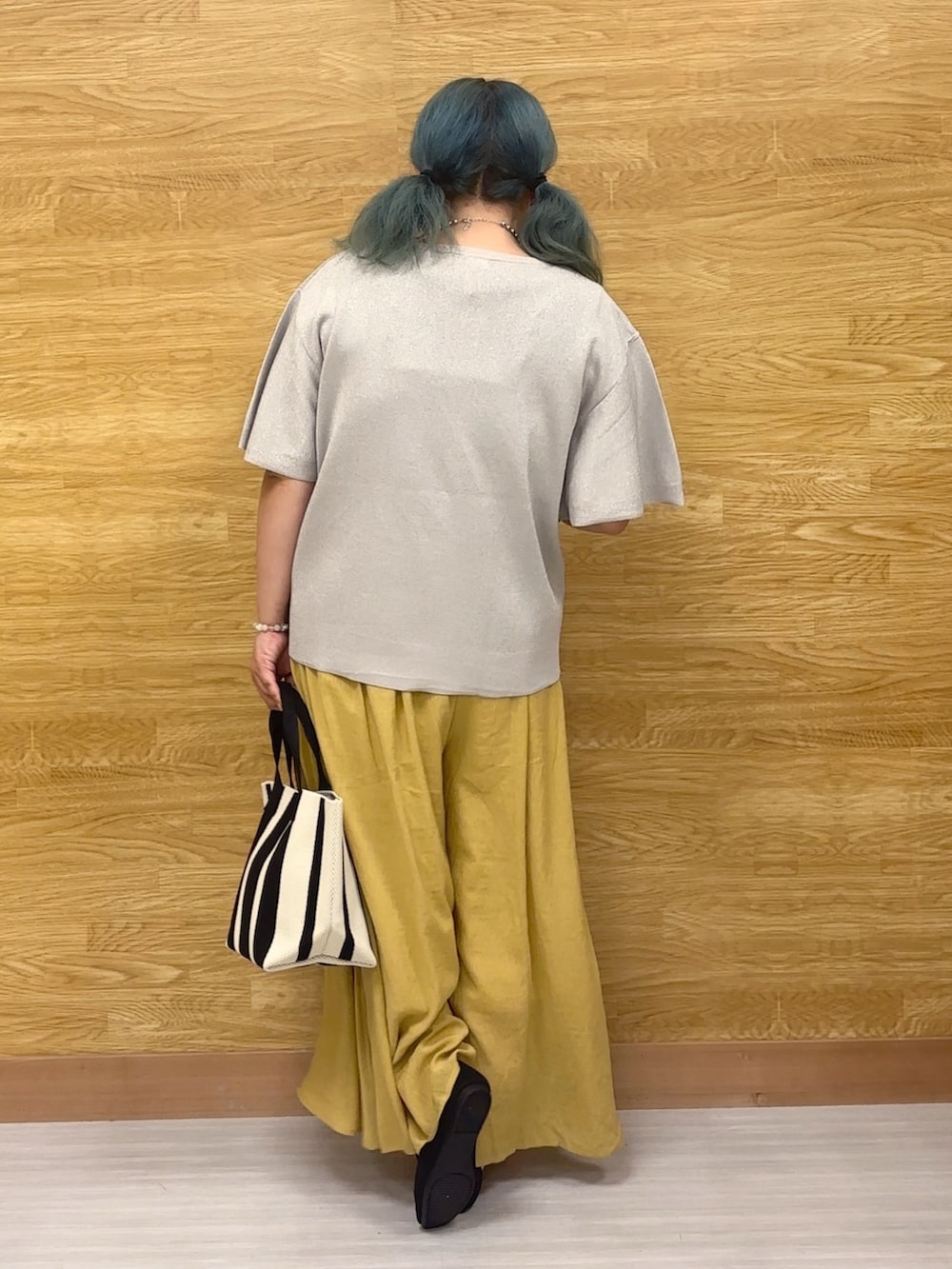 グレー系のニット/セーター、イエロー系のその他パンツ、ブラック系のトートバッグを着用したレディースの夏コーディネートの2枚目の写真