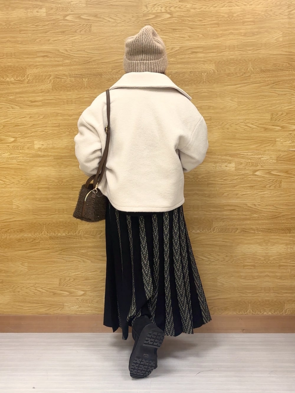 ホワイト系のブルゾン、ブラック系のスカート、ブラック系のニット/セーターを着用したレディースの秋コーディネートの2枚目の写真