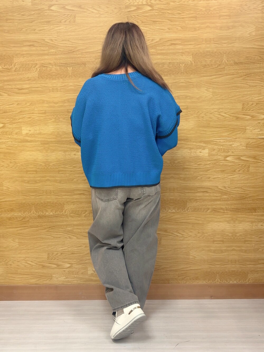 ブルー系のニット/セーター、グレー系のデニムパンツ、ホワイト系のスニーカーを着用したレディースの冬コーディネートの4枚目の写真