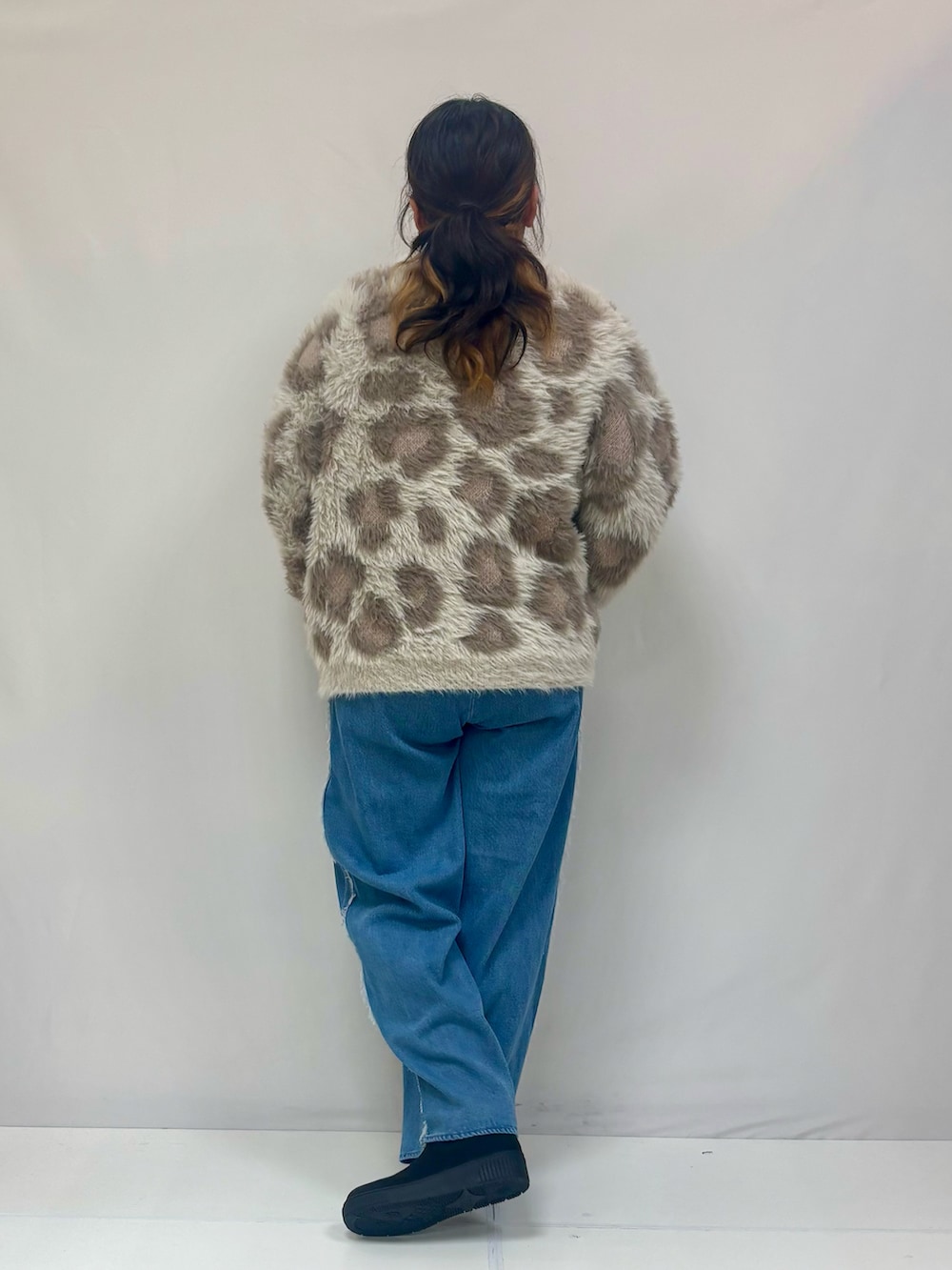 ベージュ系のニット/セーター、ブルー系のデニムパンツ、ブラック系のブーツを着用したレディースの冬コーディネートの3枚目の写真