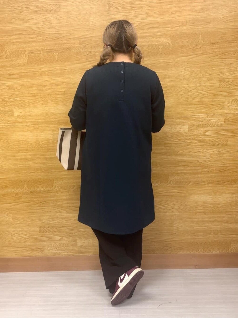 グリーン系のチュニック、ブラック系のその他パンツ、ブラウン系のトートバッグを着用したレディースの秋コーディネートの3枚目の写真