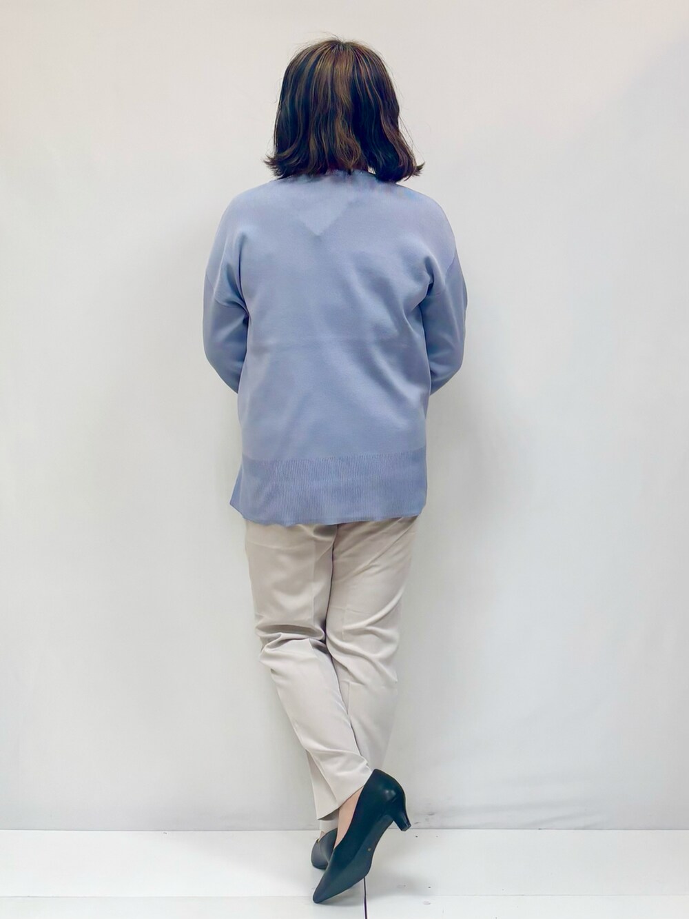 ブルー系のニット/セーター、ホワイト系のその他パンツ、ブラック系のパンプスを着用したレディースの春コーディネートの2枚目の写真