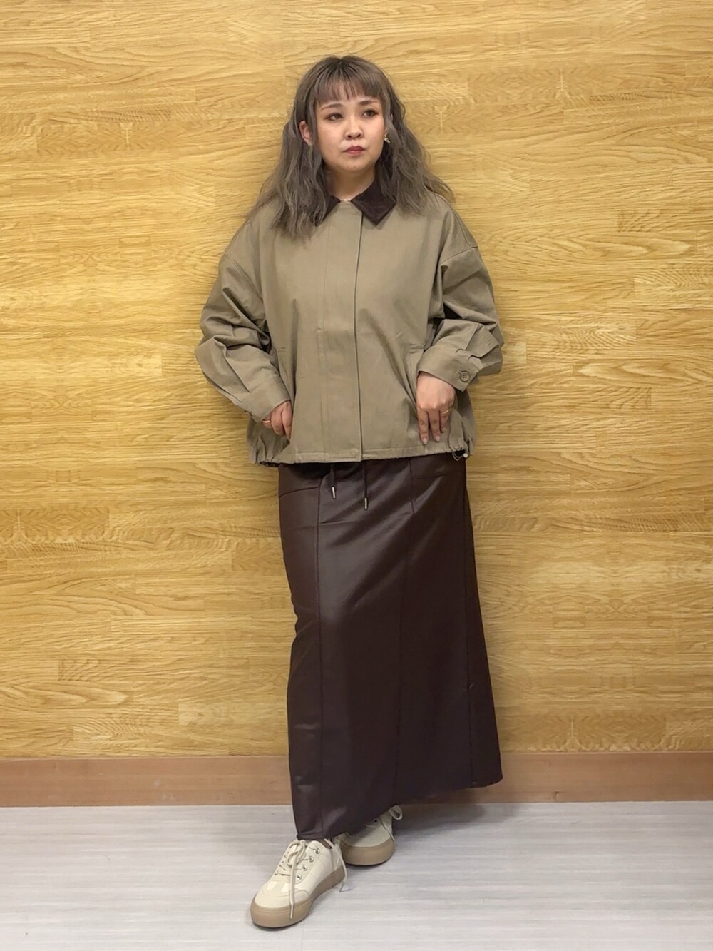 イエロー系のブルゾン、ブラウン系のスカートを着用したレディースの秋コーディネートの2枚目の写真