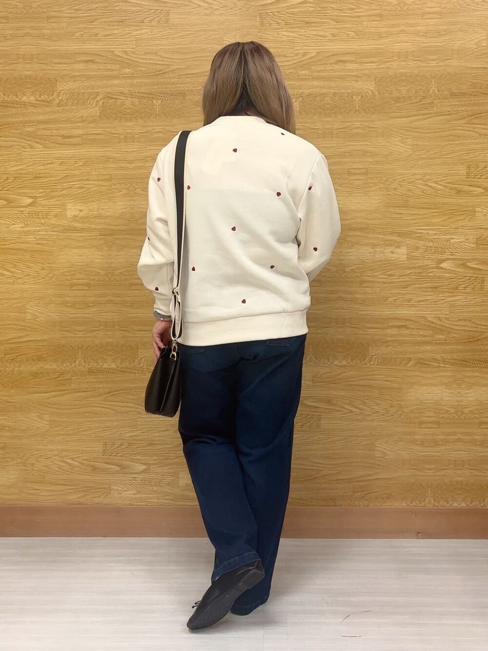 ホワイト系のスウェット、ブルー系のデニムパンツ、ブラック系のその他シューズを着用したレディースの冬コーディネートの3枚目の写真