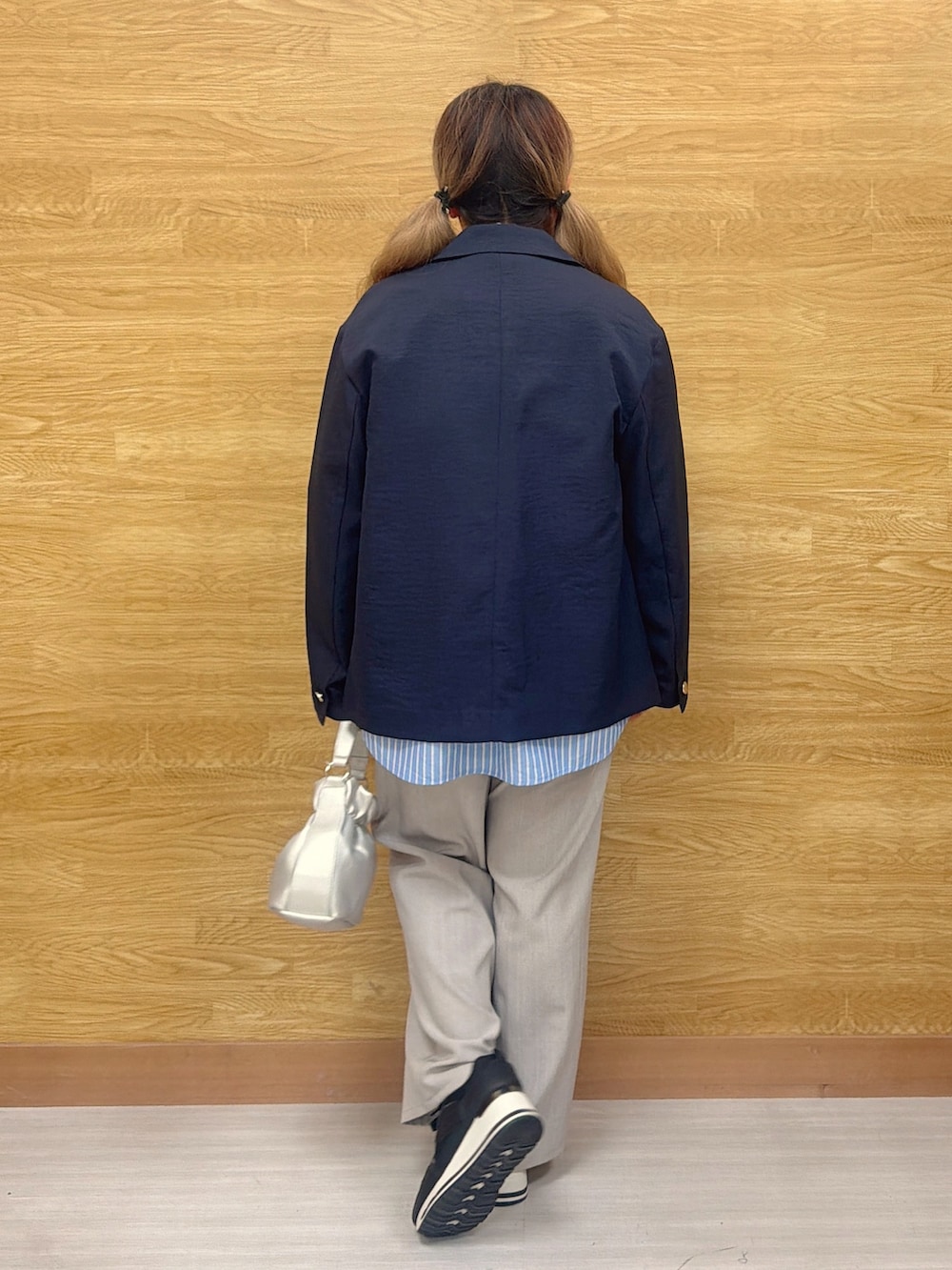 グレー系のその他パンツ、ブラック系のスニーカー、ブルー系のテーラードジャケットを着用したレディースの春コーディネートの3枚目の写真