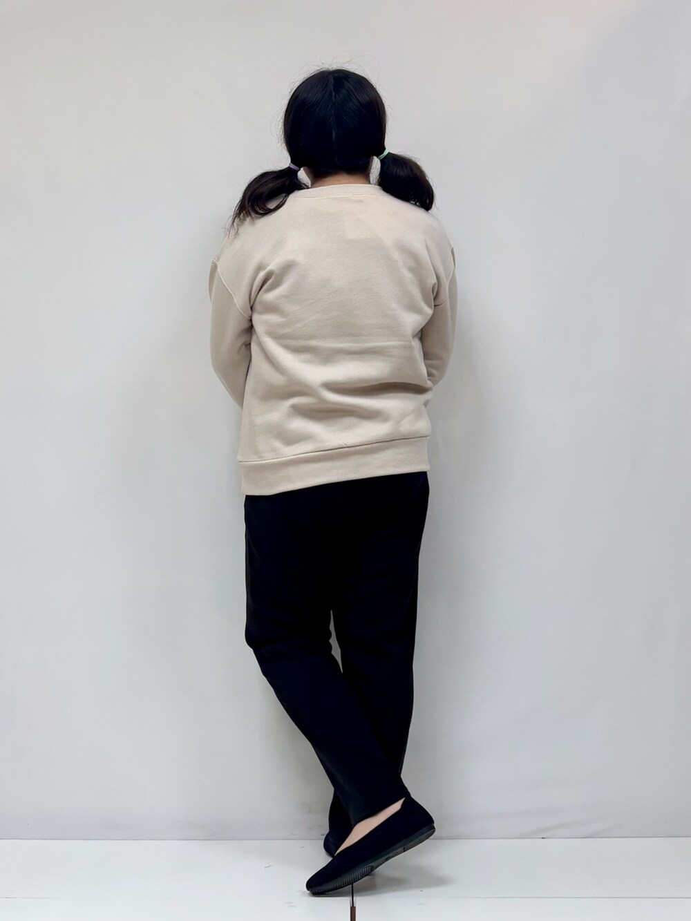 ベージュ系のTシャツ/カットソー、ブラック系のパンプス、ブラック系のその他パンツを着用したレディースの冬コーディネートの3枚目の写真