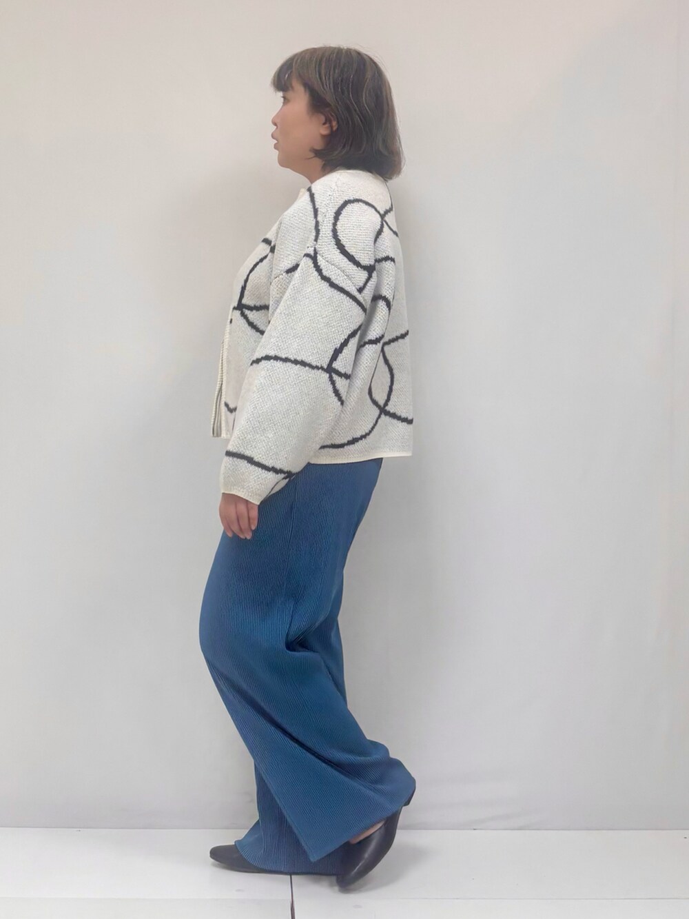 ホワイト系のカーディガン/ボレロ、ブラック系のパンツ、ブラック系のその他シューズを着用したレディースの冬コーディネートの2枚目の写真