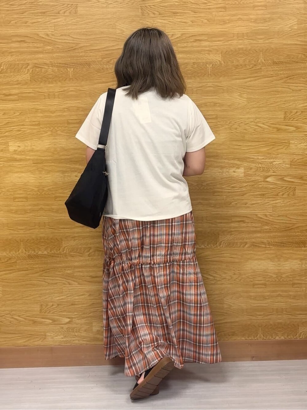 ホワイト系のTシャツ/カットソー、オレンジ系のスカート、ブラック系のサンダルを着用したレディースの夏コーディネートの3枚目の写真
