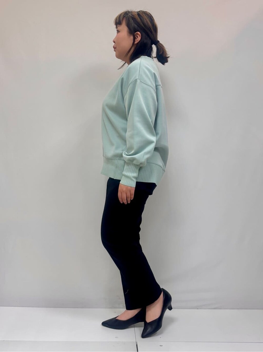 グリーン系のTシャツ/カットソー、ブラック系のその他パンツ、ブラック系のパンプスを着用したレディースの春コーディネートの2枚目の写真