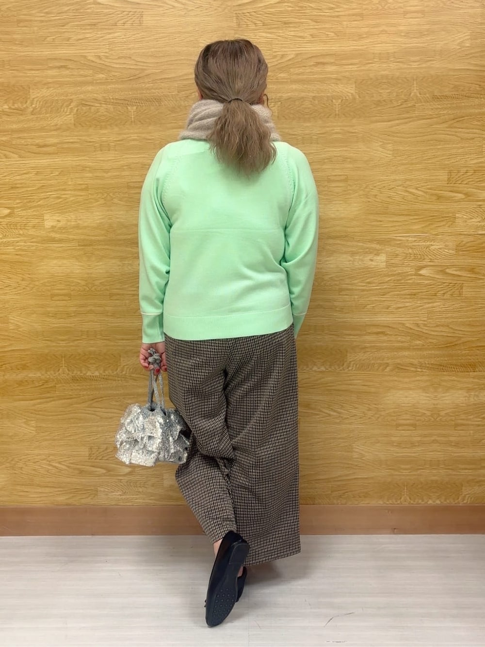 グリーン系のニット/セーター、ブラウン系のその他パンツ、ブラック系のその他シューズを着用したレディースの冬コーディネートの3枚目の写真