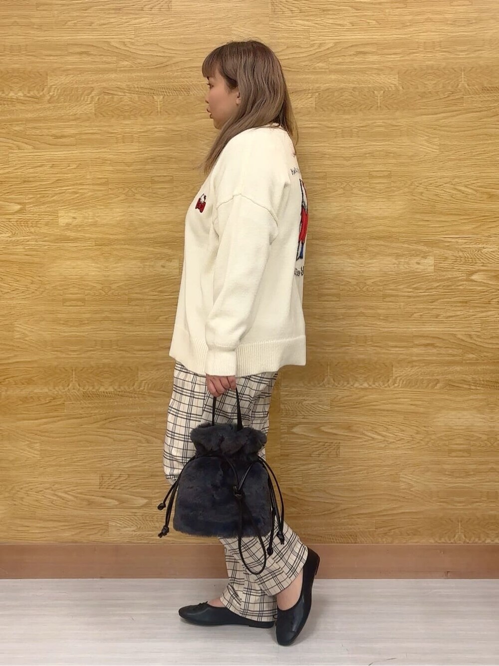 ホワイト系のカーディガン/ボレロ、イエロー系のニット/セーター、グレー系のその他パンツを着用したレディースの冬コーディネートの2枚目の写真