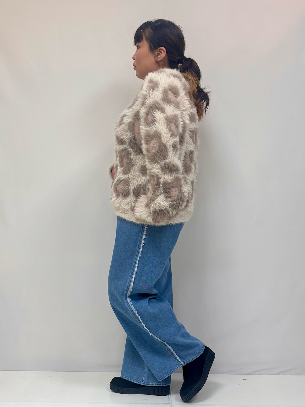 ベージュ系のニット/セーター、ブルー系のデニムパンツ、ブラック系のブーツを着用したレディースの冬コーディネートの2枚目の写真