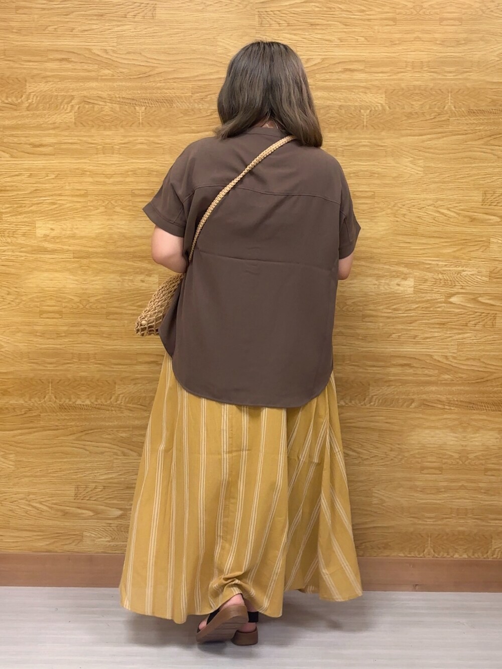 ブラウン系のシャツ/ブラウス、イエロー系のスカートを着用したレディースの夏コーディネートの2枚目の写真