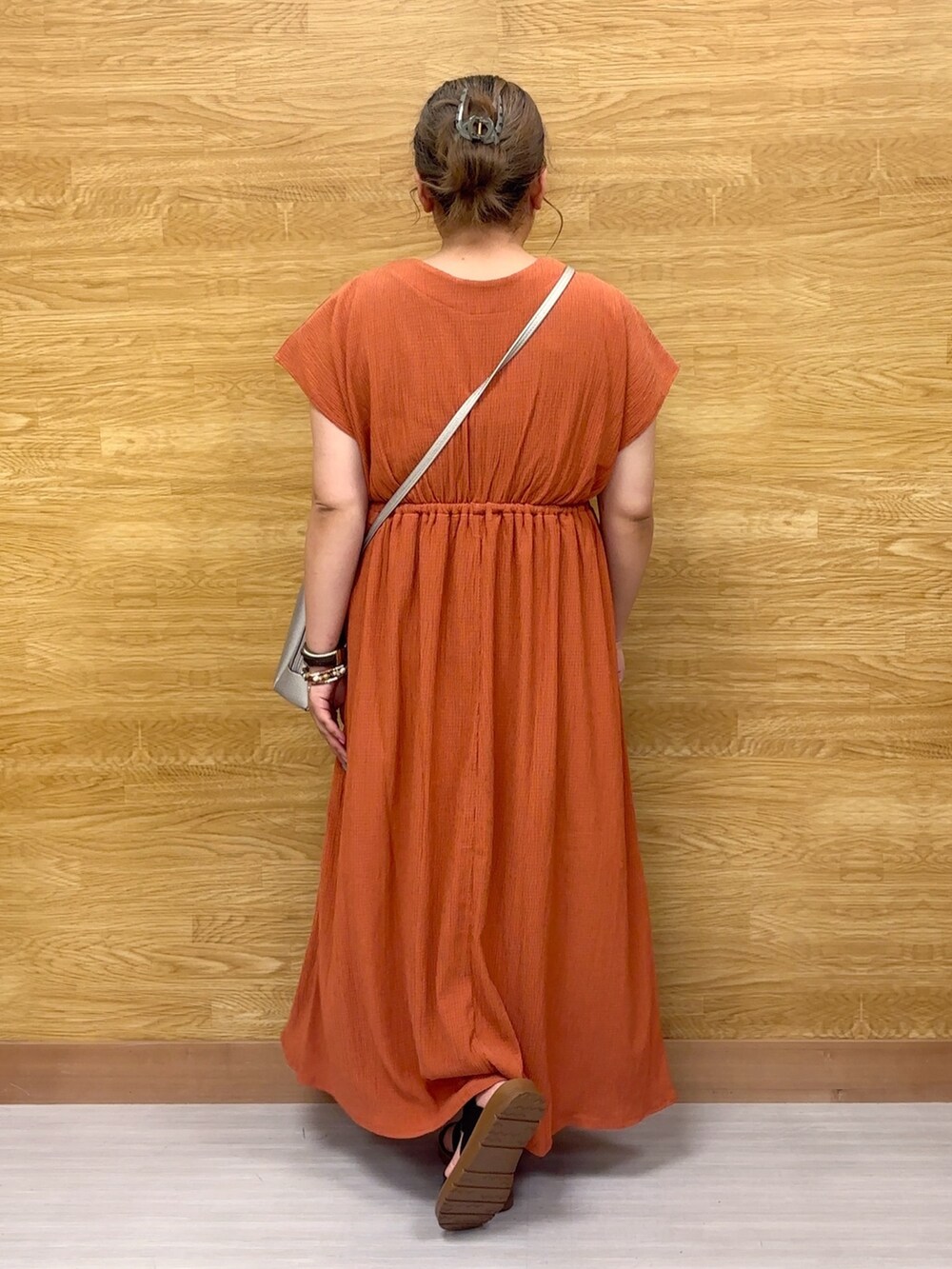 オレンジ系のワンピースを着用したレディースの夏コーディネートの2枚目の写真