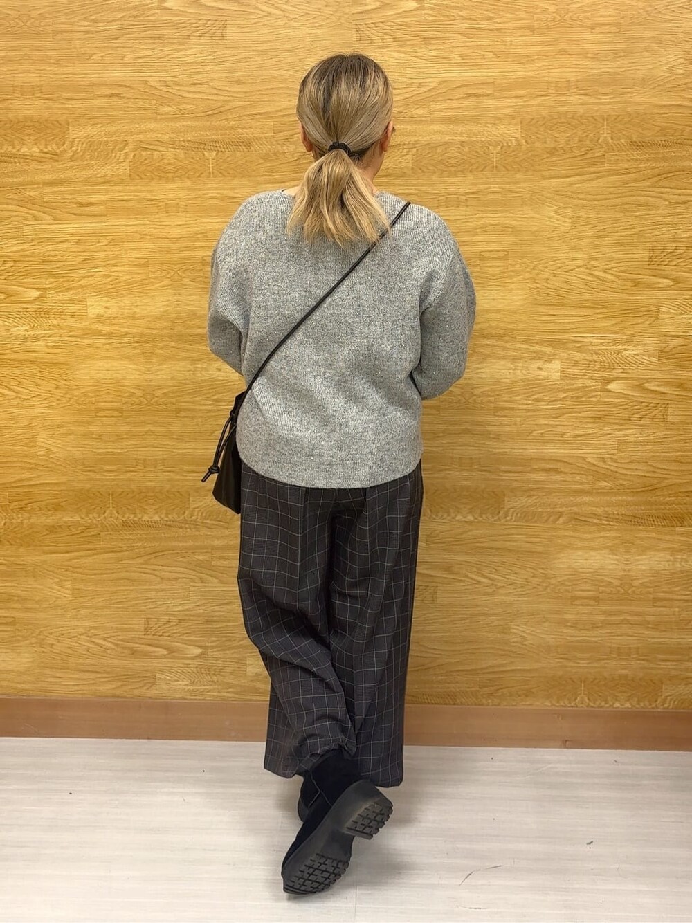 グレー系のニット/セーター、グレー系のその他パンツ、ブラック系のブーツを着用したレディースの冬コーディネートの3枚目の写真