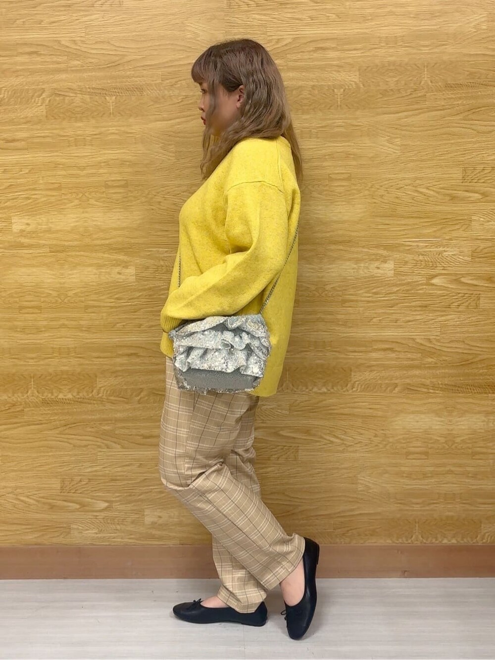 イエロー系のニット/セーター、ベージュ系のその他パンツ、ブラック系のその他シューズを着用したレディースの冬コーディネートの2枚目の写真