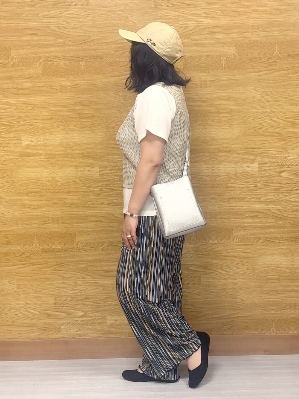 ブルー系のその他パンツ、ブラック系のパンプス、シルバー系のショルダーバッグを着用したレディースの夏コーディネートの2枚目の写真