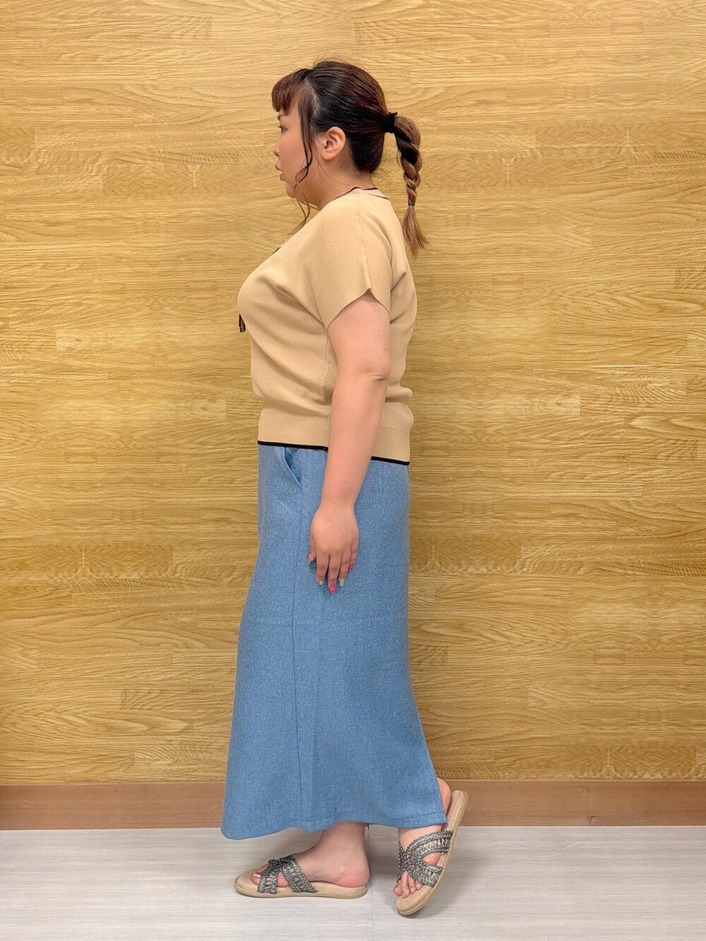 ベージュ系のニット/セーター、ブルー系のスカート、ブラウン系のサンダルを着用したレディースの夏コーディネートの2枚目の写真