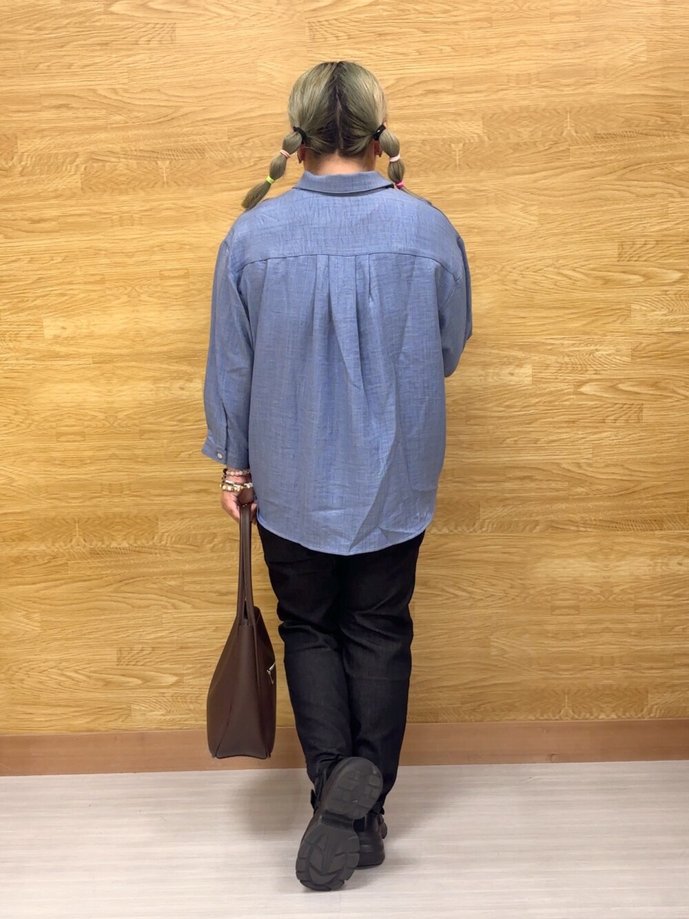 ブラック系のデニムパンツ、ブルー系のシャツ/ブラウスを着用したレディースの秋コーディネートの2枚目の写真