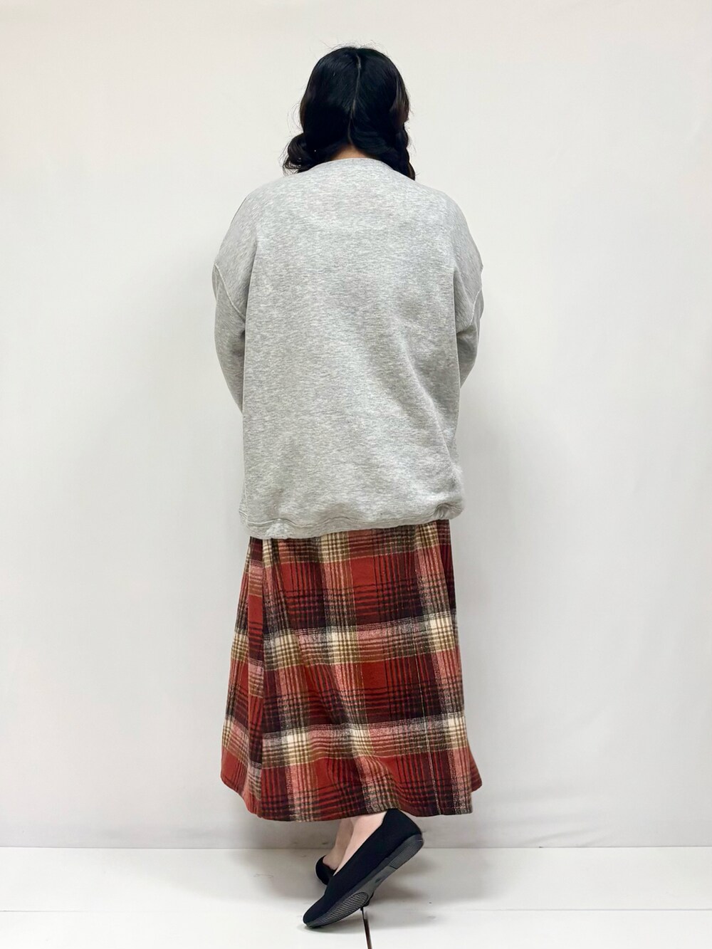 ベージュ系のスカート、ブラック系のパンプス、グレー系のTシャツ/カットソーを着用したレディースの冬コーディネートの3枚目の写真